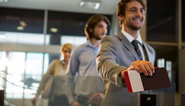 businessman-standing-with-boarding-pass-check-counter_107420-63615
